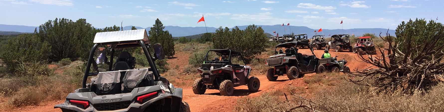 A large group of off highway vehicles on a red dirt trail in the Sedona area