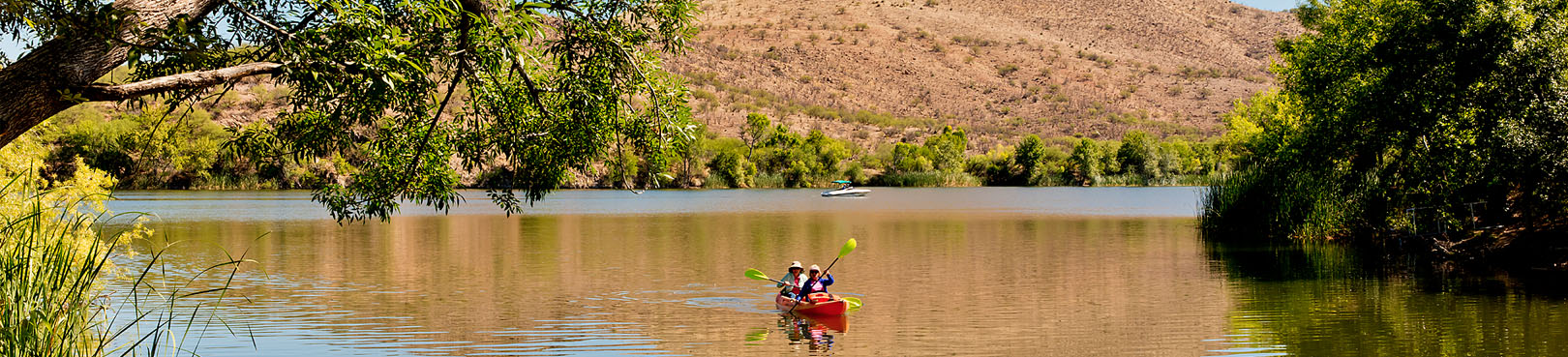 Two people in a red kayak explore Patagonia Lake on a sunny day