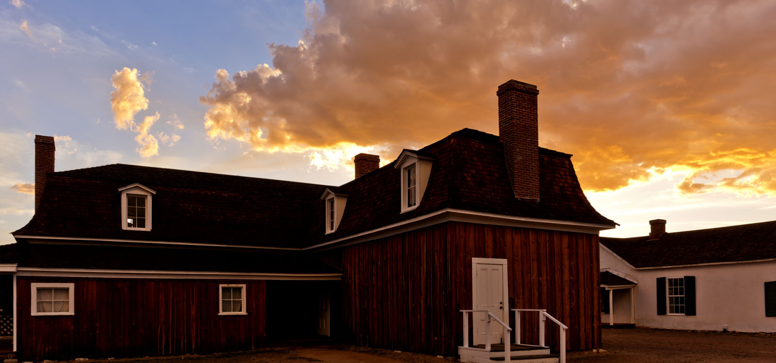 The sun sets behind one of the main buildings at Fort Verde State Historic Park