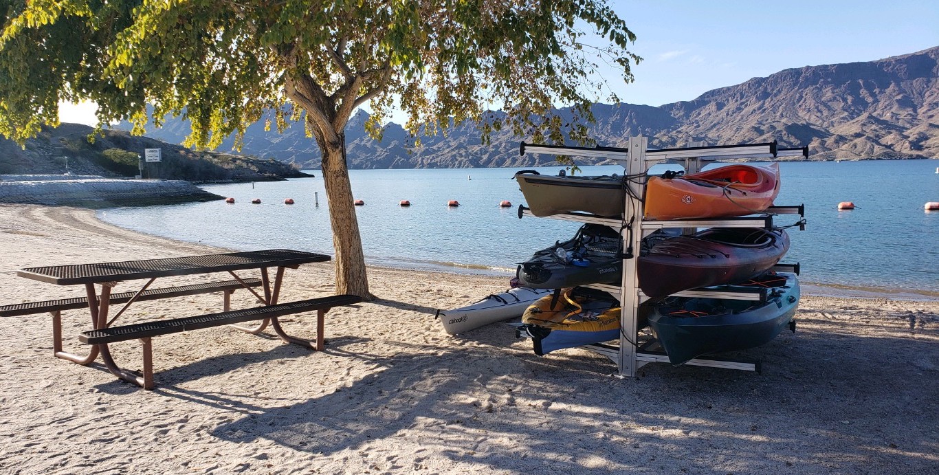 Kayaks are stacked for rent on the white sand beach at Cattail Cove