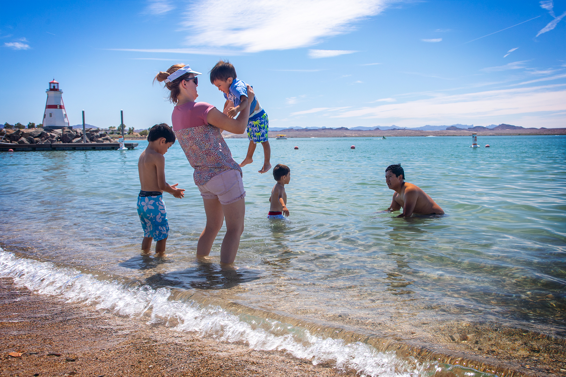 A family plays on the shallow water of the beach at Lake Havasu State Park.