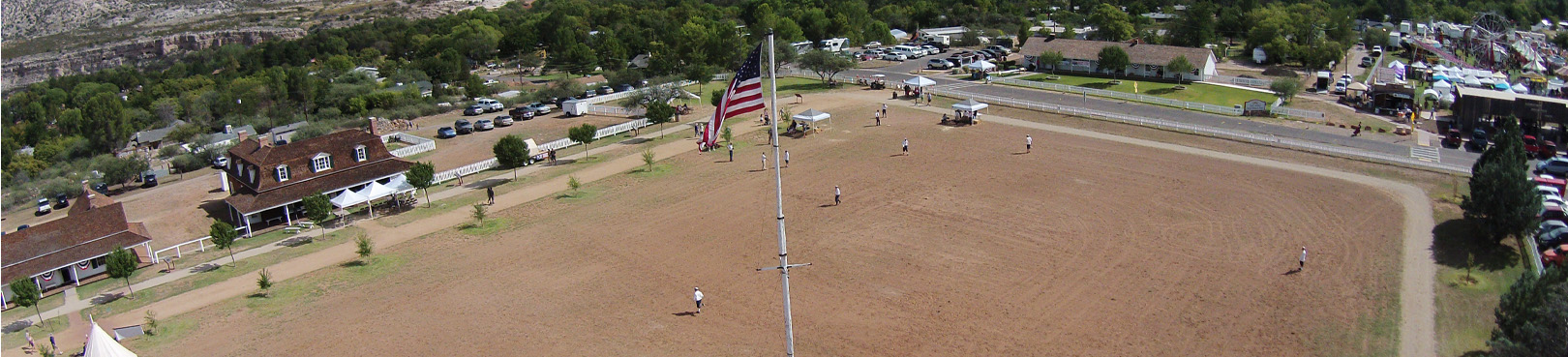 Ariel view of a baseball game being played on the the park property. Some historic buildings can be seen in the distance.