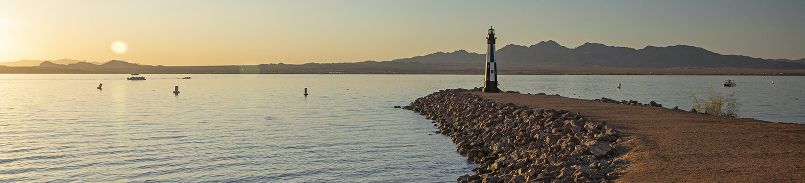 Looking west at sunset to a small peninsula on Lake Havasu that holds a replica lighthouse.