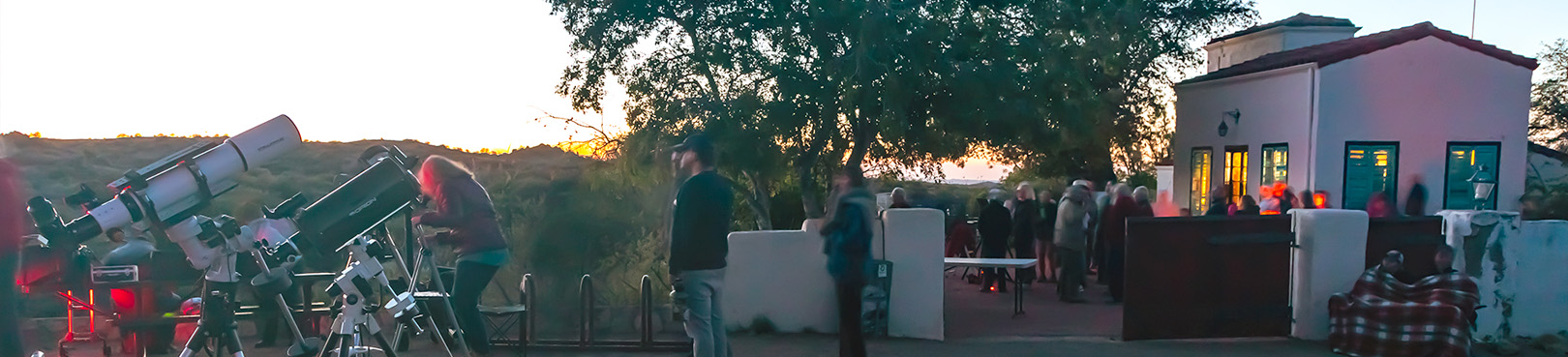 Large telescopes are pointing toward the sky while positioned just outside the Kannally Ranch House patio area.