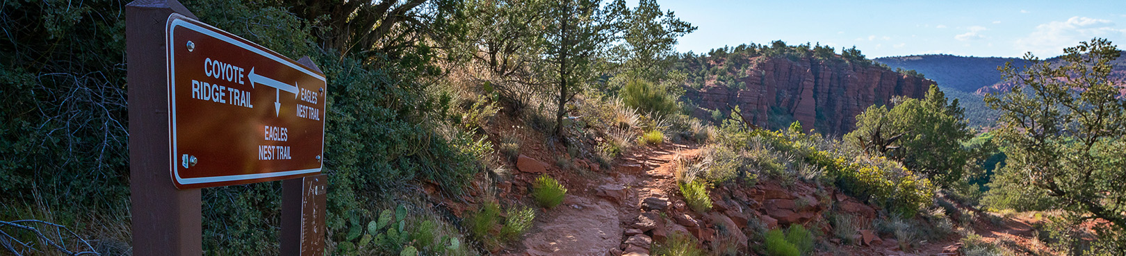 A trail sign leads the way into the red rocks and unforgettable high desert adventure.