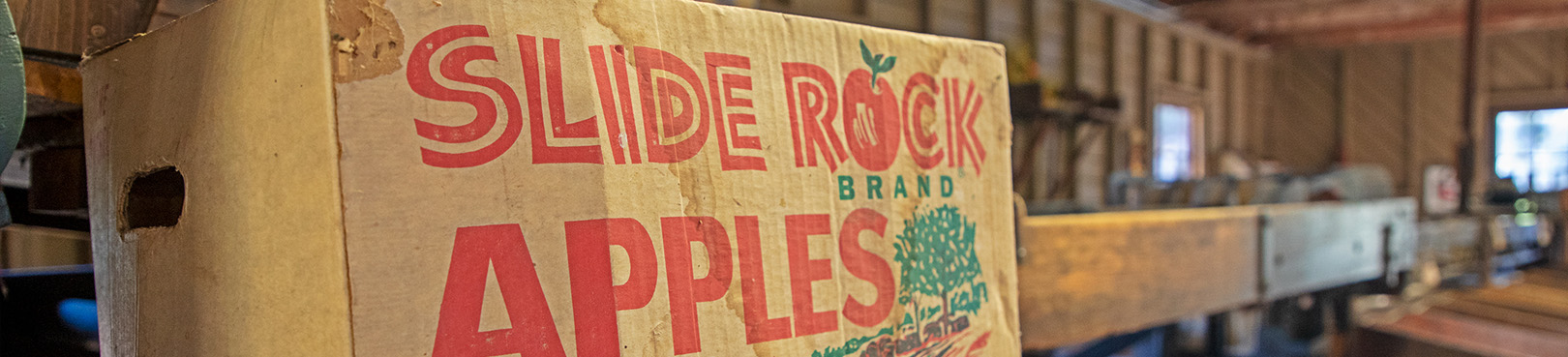 A Slide Rock Apples box sits on the assembly line at the functioning apple processing facility at the park.