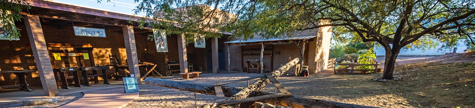 The courtyard at Tubac Presidio covered in the afternoon shade of a large mesquite tree.