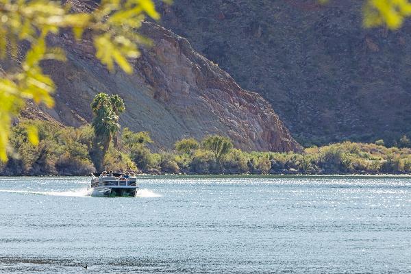 People enjoy a boat ride along the Colorado River at Buckskin Mountain State Park