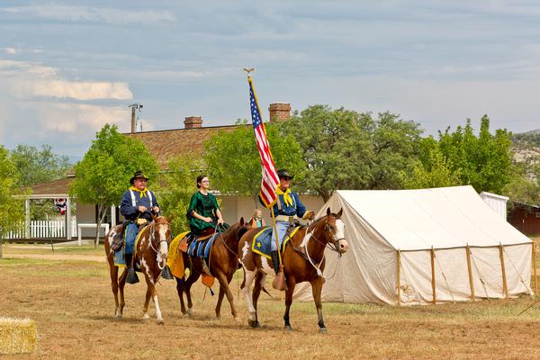 A view of one of the buildings at Fort Verde State Historic Park, with reenactors from Fort Verde Days on horses.