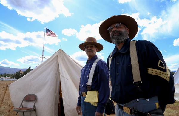 Buffalo Soldier reenactors stand at Fort Verde State Park with the American flag in the backdrop
