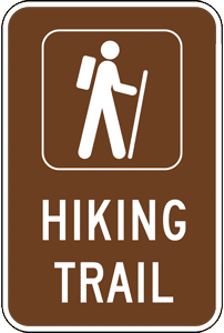 A brown directional sign that says Hiking Trail