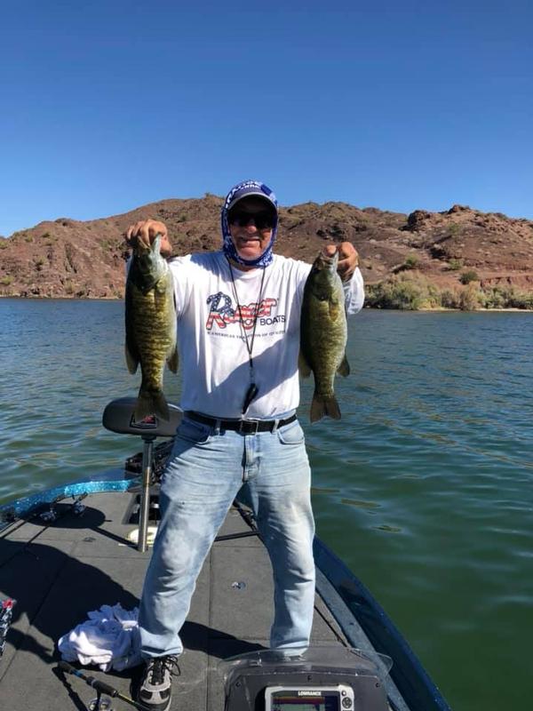 A happy angler with two big Lake Havasu Smallmouth Bass