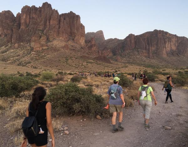 Several hikers set out on a hiking trail toward the Superstition Mountains