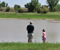 A man and child fish at the edge of Lyman Lake State Park