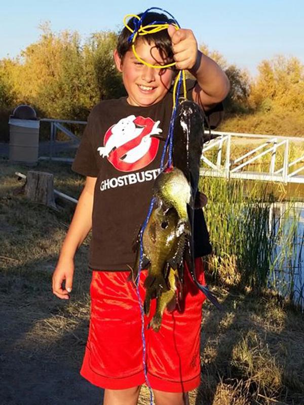 A young fisher holds his catch at Roper lake