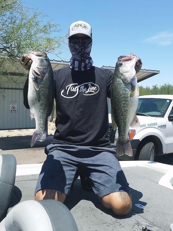 A man fishing with two caught bass at Roper Lake 