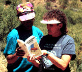 Site Stewards referencing a book while on location at an Arizona cultural site.
