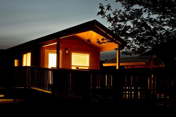 Windows glow from a rental cabin at dusk at Lyman Lake State Park