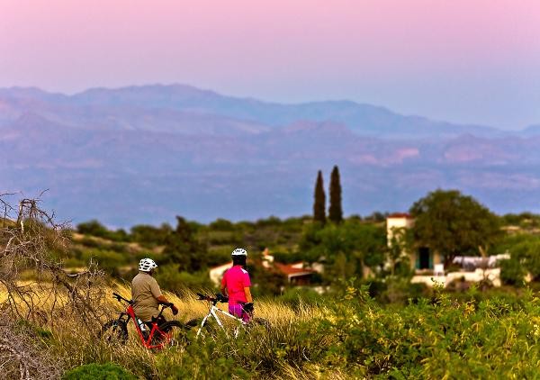 Bikers on a trail overlooking the Kannally Ranch House in southern Arizona at Oracle State Park