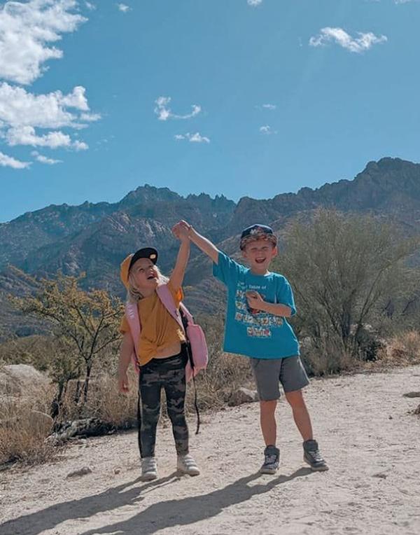 Two small kids high fiving in the desert to celebrate Arizona state parks donations.