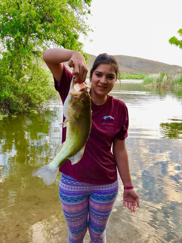 Happy angler holding a nice Patagonia Lake Largemouth Bass she caught from shore.