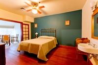 One of the bedrooms in Goodfellow Lodge, with a double bed and sink, plus separate seating area