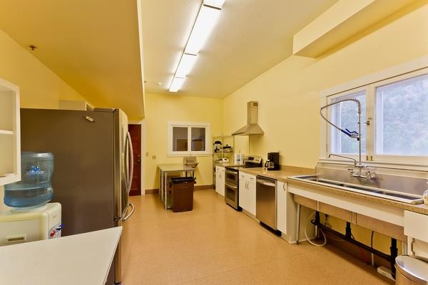 The full kitchen in the Lodge, with sink, refrigerator, and cooking area