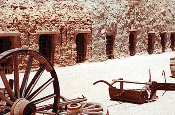 A sepia-toned picture of the cells with bars along the wall at Yuma Territorial Prison